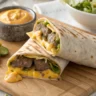 Saftiger Big Mac Wrap mit Rinderhack, Cheddar, Salat, Gurken und Big-Mac-Soße in einer Tortilla