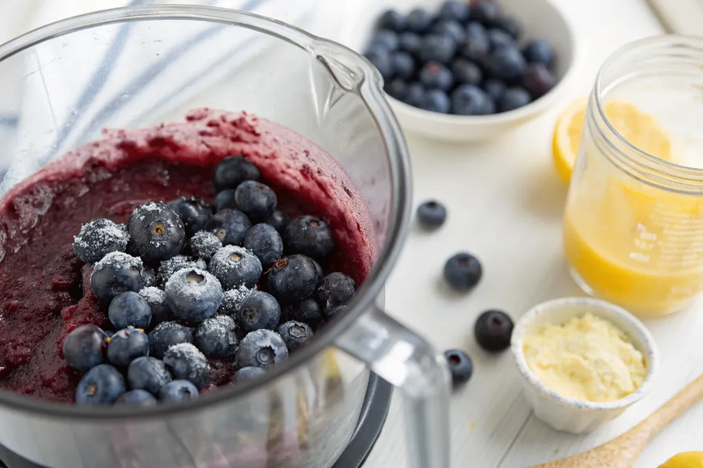 Blaubeeren werden mit Zucker und Zitronensaft im Mixer püriert