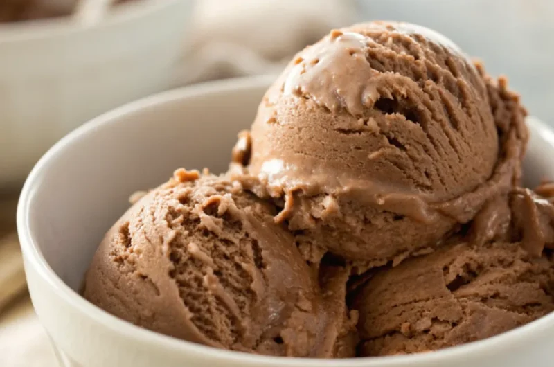 Cremiges Nutella Eis selber machen in einer Schale, garniert mit gehackten Haselnüssen